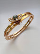 CHUNKY 15CT GOLD BANGLE WITH A LARGE GEM SET FLY