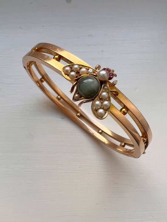 CHUNKY 15CT GOLD BANGLE WITH A LARGE GEM SET FLY