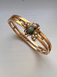 CHUNKY 15CT GOLD BANGLE WITH A LARGE GEM SET FLY