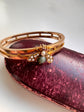 CHUNKY 15CT GOLD BANGLE WITH A LARGE GEM SET FLY