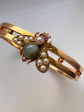 CHUNKY 15CT GOLD BANGLE WITH A LARGE GEM SET FLY